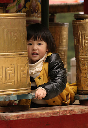 Chinese girl in prayer wheels